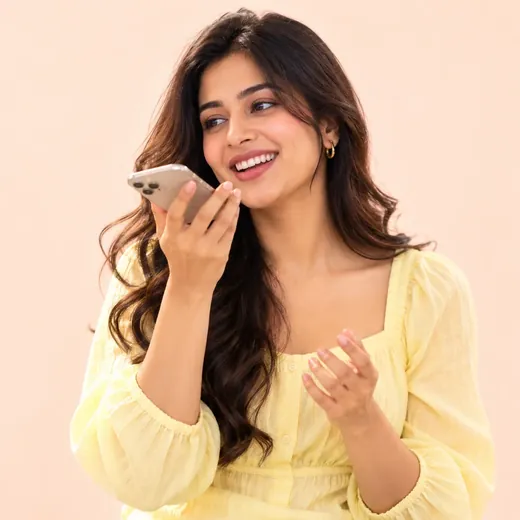 A woman holding her phone close to speak into it